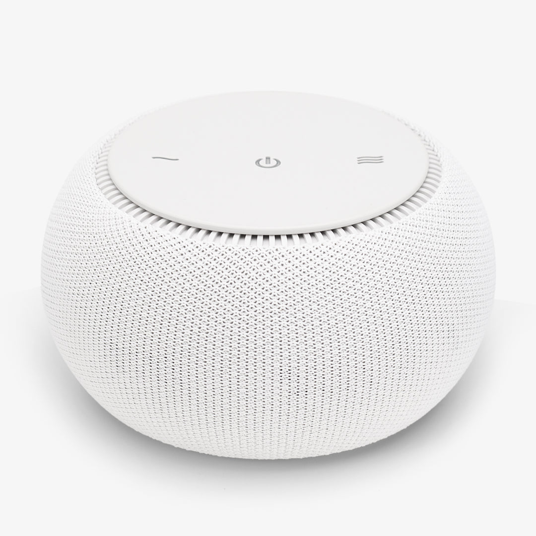 Round white speaker with mesh design and minimalistic buttons on top.